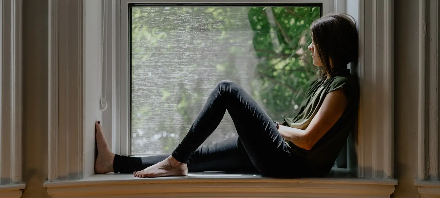 a woman sitting on a window sill