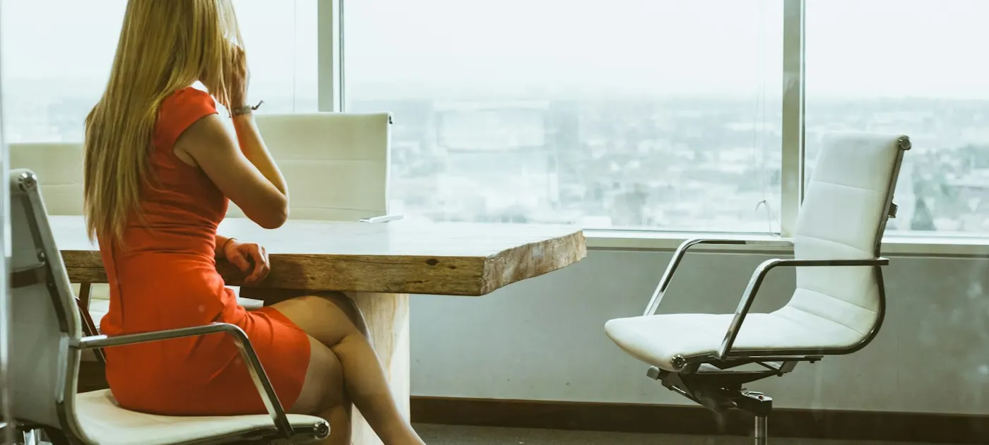 woman talking through mobile phone while sitting on swivel armchair