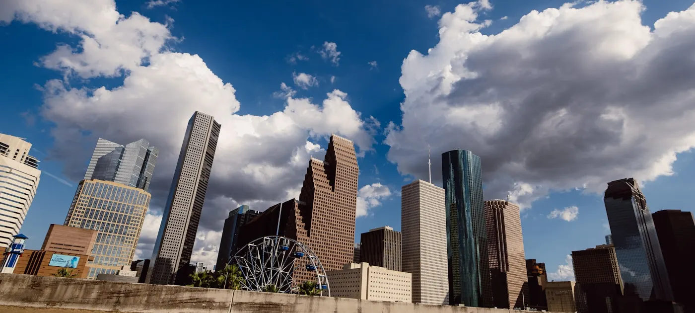 Modern skyscrapers under a cloudy blue sky.
