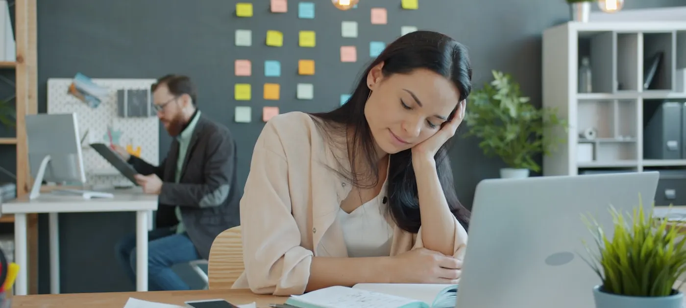 Woman resting head on hand at desk