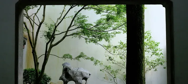 Tranquil garden scene viewed through a decorative window