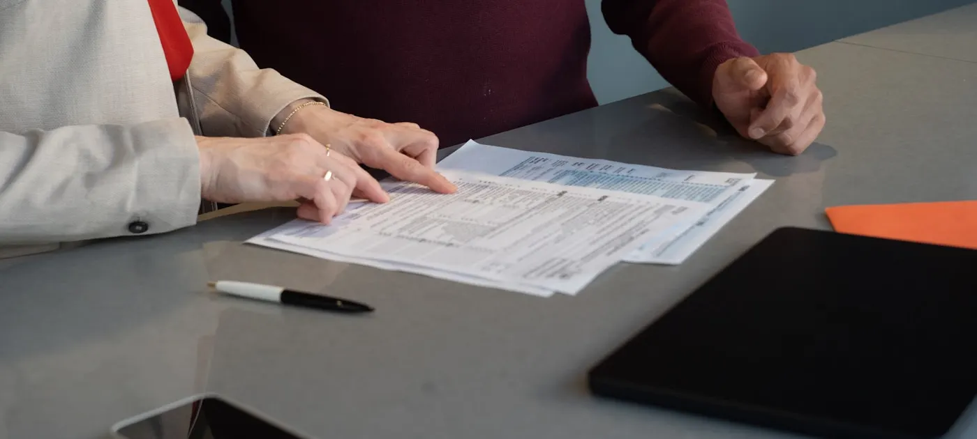 Two people reviewing documents at a table.