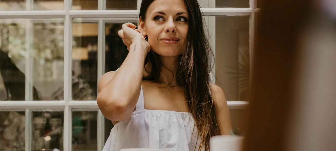 a woman sitting at a table in front of a window